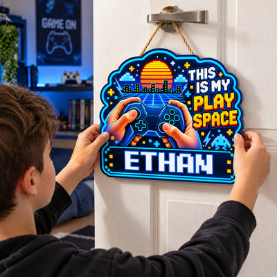 Personalized wooden sign gamer controller held against a door by a person in a black hoodie, gaming room behind