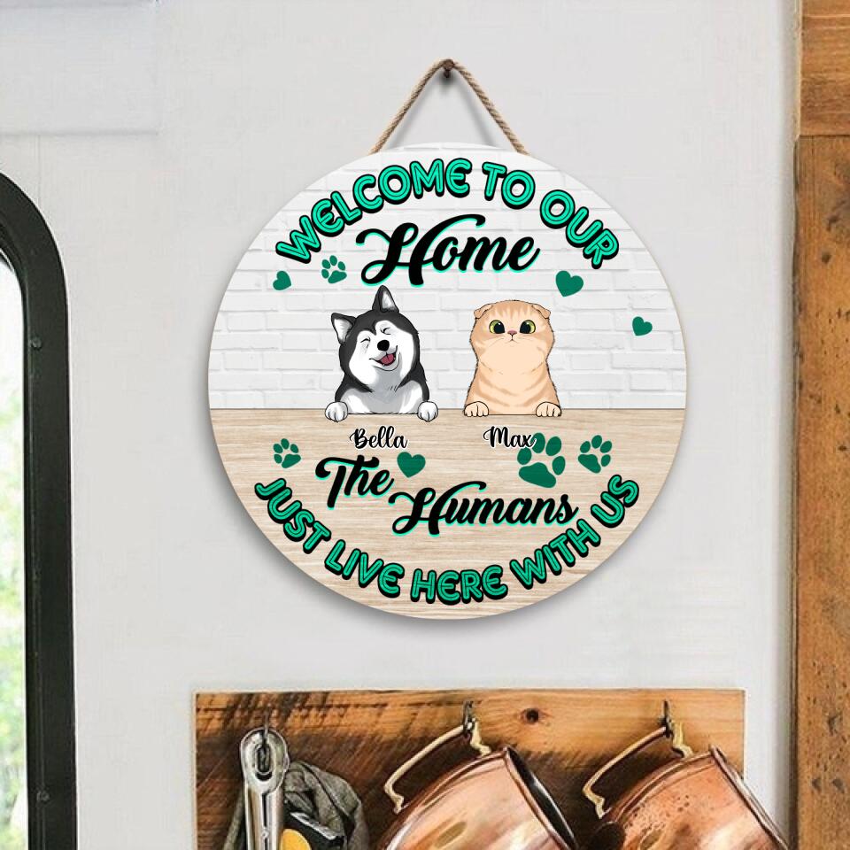 Welcome To Our Home, The Humans Just Live Here With Us - Personalized  Wooden Door Sign