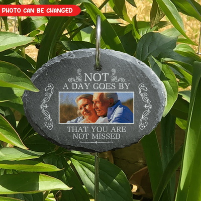 Decorative slate plaque with photo of an elderly couple and text in a garden setting