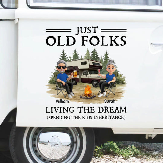 Decorative banner with 'Just Old Folks' design on a vehicle, featuring two people by a campfire with a camper in the background.