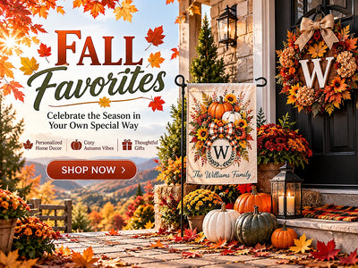 Personalized fall home decor featuring a pumpkin and sunflower garden flag, autumn wreath, mums and lanterns on a welcoming front porch.