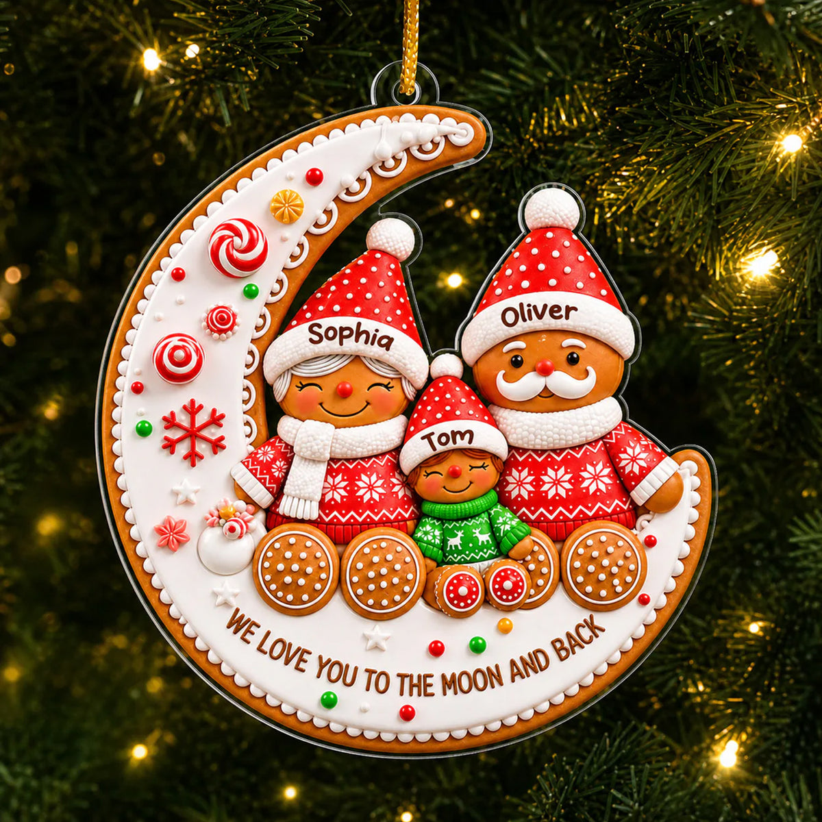 Gingerbread Family Moon Personalize Acrylic Ornament hanging on a green tree with warm string lights