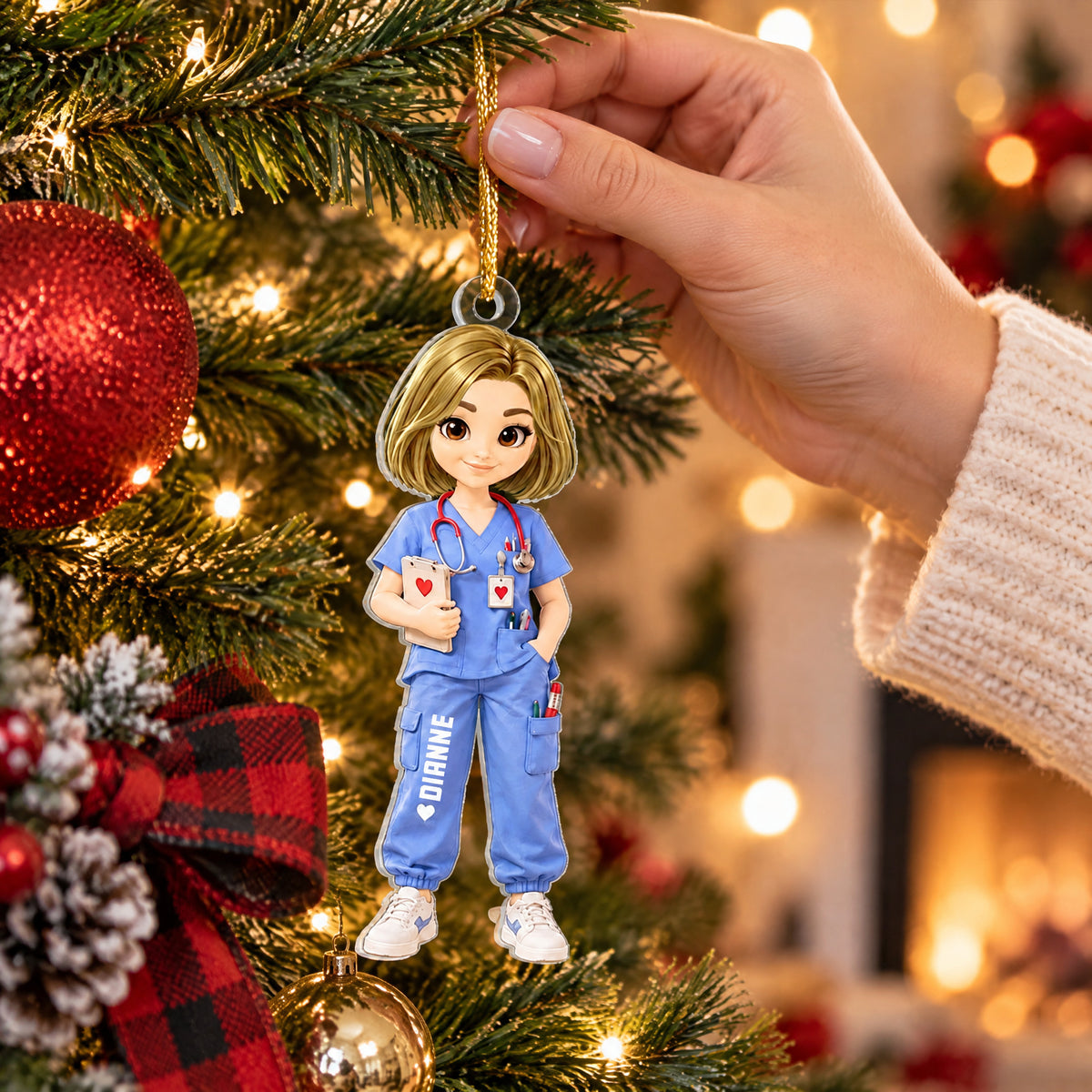 Personalized nurse acrylic ornament hung on a pine branch with a plaid ribbon and a hand reaching in