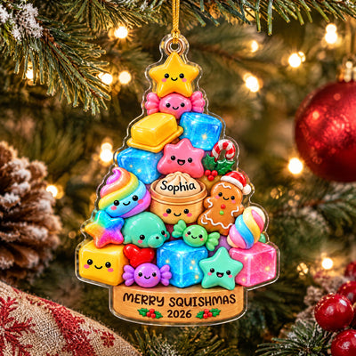 Personalized acrylic Squishmallow ornament hanging among tree lights, a red bauble, berries and a burlap stocking