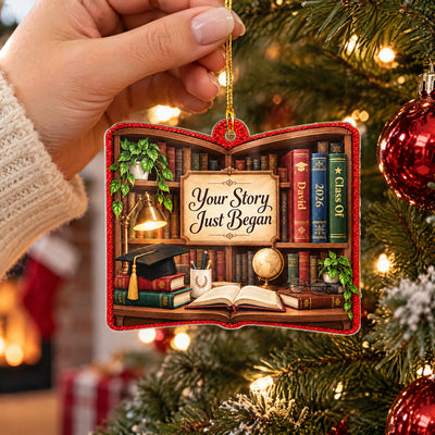 Personalized acrylic library shelf ornament held up near a Christmas tree with red baubles and a cozy knit sleeve