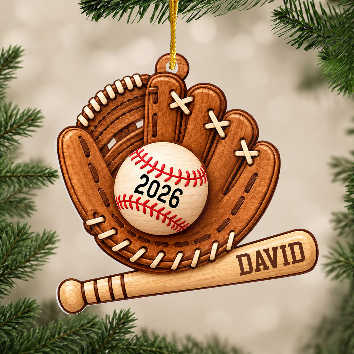 Personalized baseball acrylic ornament hanging from a gold cord on a pine branch with a soft blurred background
