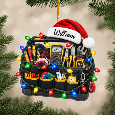 Personalized electrician tool bag acrylic ornament with Santa hat and name, shown among green pine branches
