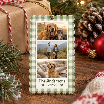 Personalized acrylic photo collage ornament lying on a wooden table with a wrapped gift, pinecone and red berries