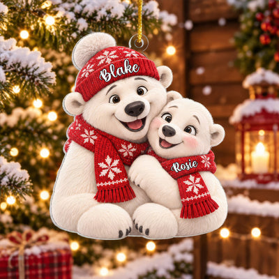 Personalized polar bear couple acrylic ornament held by hand in front of a lit tree, names Blake and Rosie on red scarves