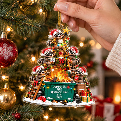 Personalized Acrylic Christmas Ornament held in a hand in front of a lit tree with red and gold baubles