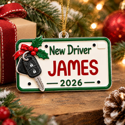 Personalized New Driver Acrylic Ornament lying on a wooden surface with a gift, pinecone and tree branches
