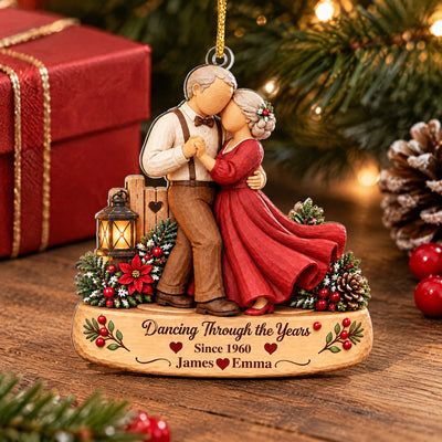 Personalized Acrylic Ornament Dancing Couple standing on a wooden table beside a red gift box and pinecone