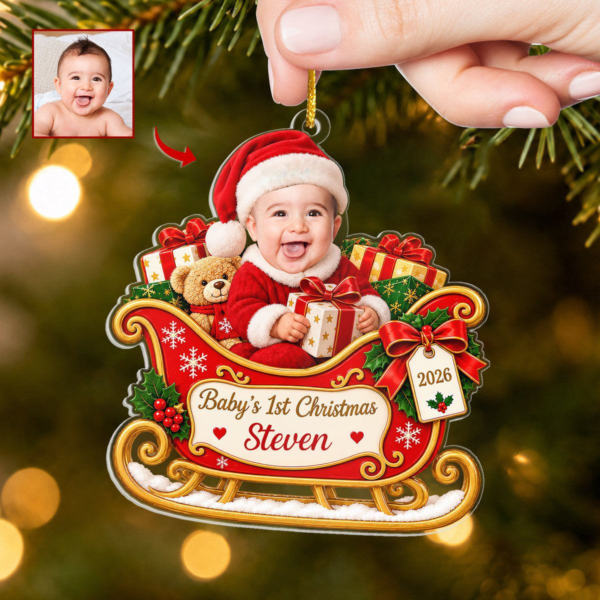 Personalized Custom Baby Face Acrylic Ornament held by a hand on a gold cord against a softly lit green tree