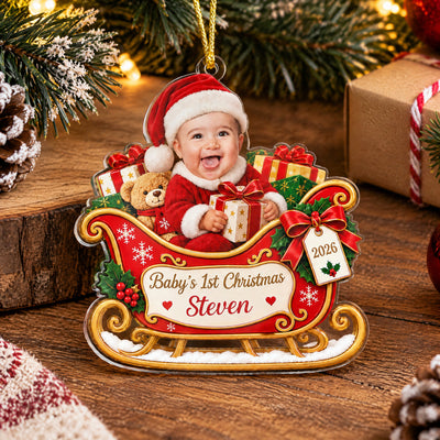 Personalized Custom Baby Face Acrylic Ornament standing on a wooden table with pinecones and a wrapped gift nearby