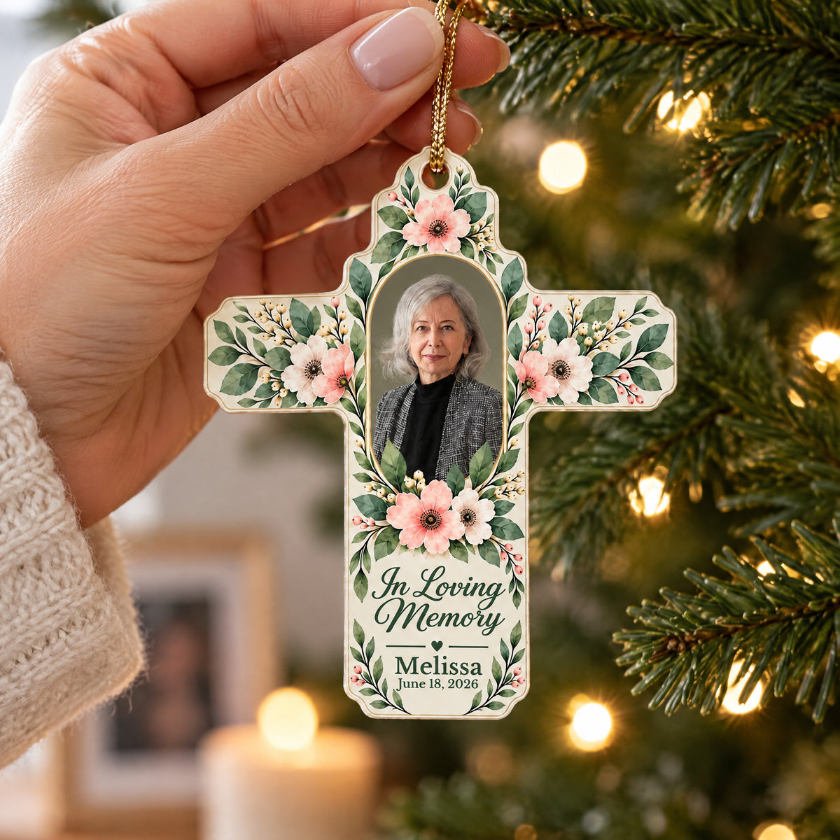 Personalized Floral Cross Acrylic Ornament held by hand near tree lights, In Loving Memory text and name below