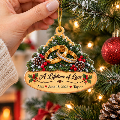 Personalized golden rings acrylic ornament held by a hand in a knit sleeve, hanging on a tree by its gold cord