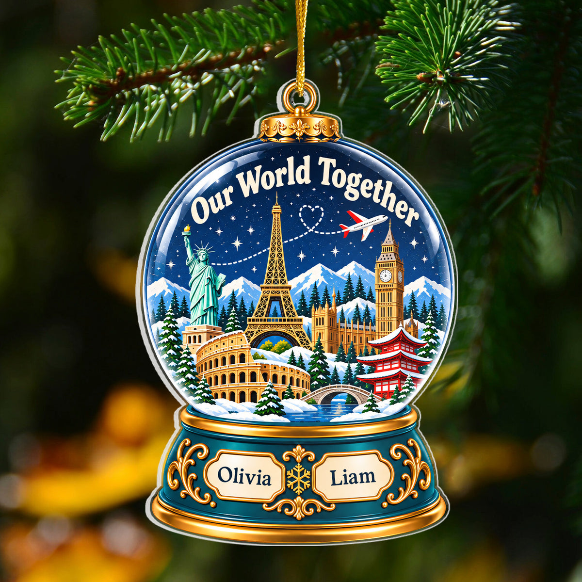 Personalized acrylic snow globe ornament with names Olivia and Liam hanging from a pine branch