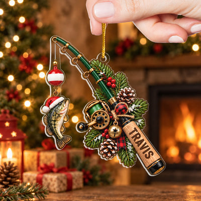 Personalized Acrylic Fishing Ornament held up in front of a fireplace, tree and wrapped gifts