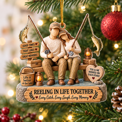 Personalized Acrylic Ornament Reeling In Life Together hanging on a pine branch beside red glitter baubles