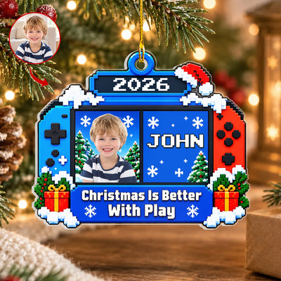 Personalized Acrylic Gamer Ornament with a boy's photo and the name John, beside a pinecone on a wooden surface