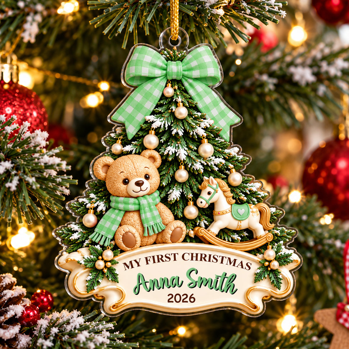 Personalized Teddy Bear Acrylic Ornament with green bow hanging on a tree, close view of the name banner