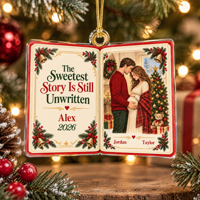 Personalized acrylic book ornament hanging on a decorated Christmas tree with red baubles and warm lights