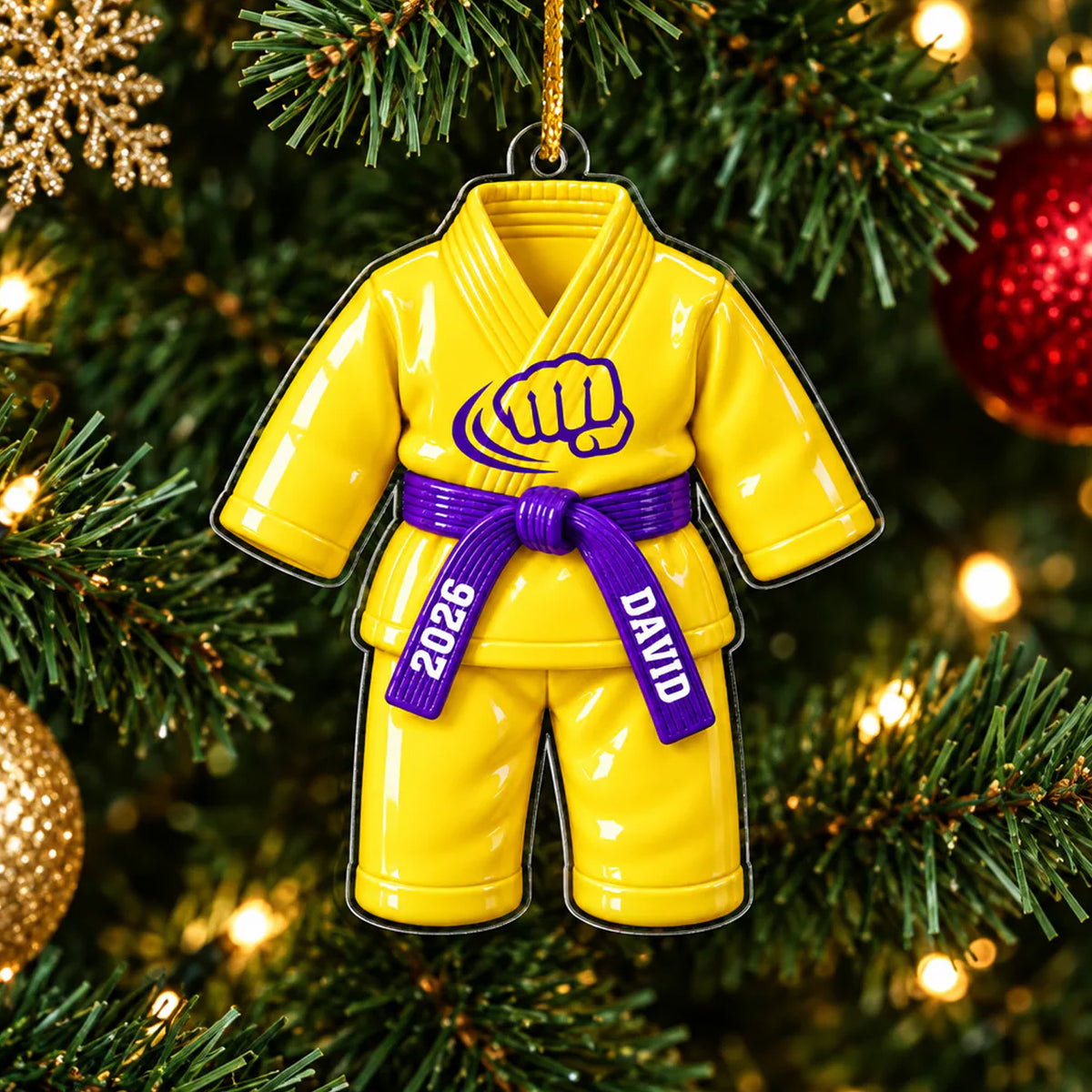 Personalized karate uniform acrylic ornament in yellow with purple belt hanging on a lit Christmas tree