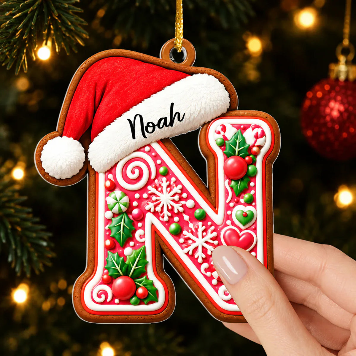 Personalized Gingerbread Initial Letter Acrylic Ornament, letter N held in a hand in front of tree lights