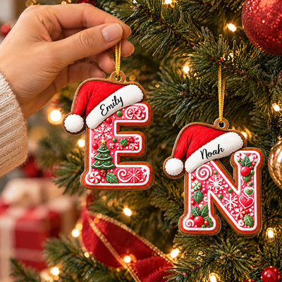Personalized Gingerbread Initial Letter Acrylic Ornament, E and N hung on a tree, one held by a hand