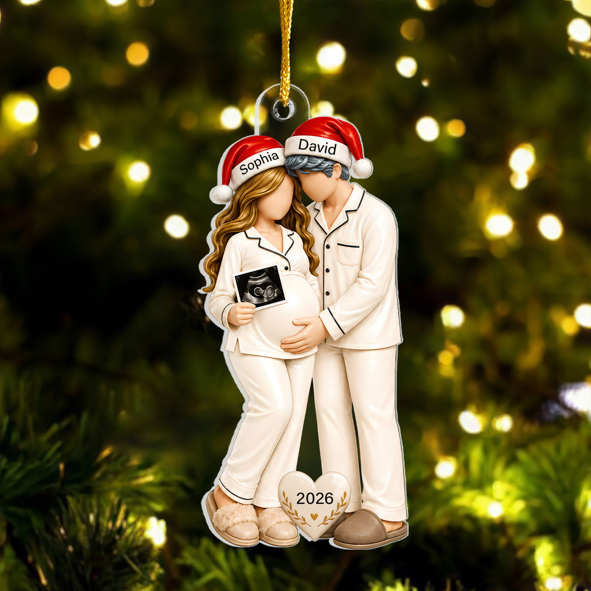 Personalized Pregnancy Christmas Acrylic Ornament hanging on a lit tree, couple in cream pajamas and Santa hats