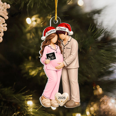 Personalized Pregnancy Christmas Acrylic Ornament with the woman in pink pajamas, hung on a pine branch