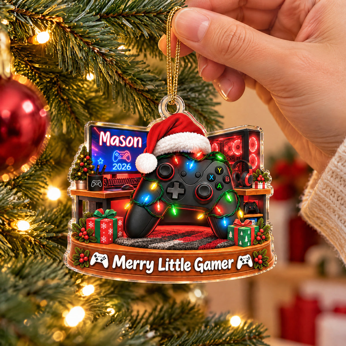 Personalized Acrylic Santa Hat Controller Ornament held by a hand beside a red bauble on a tree