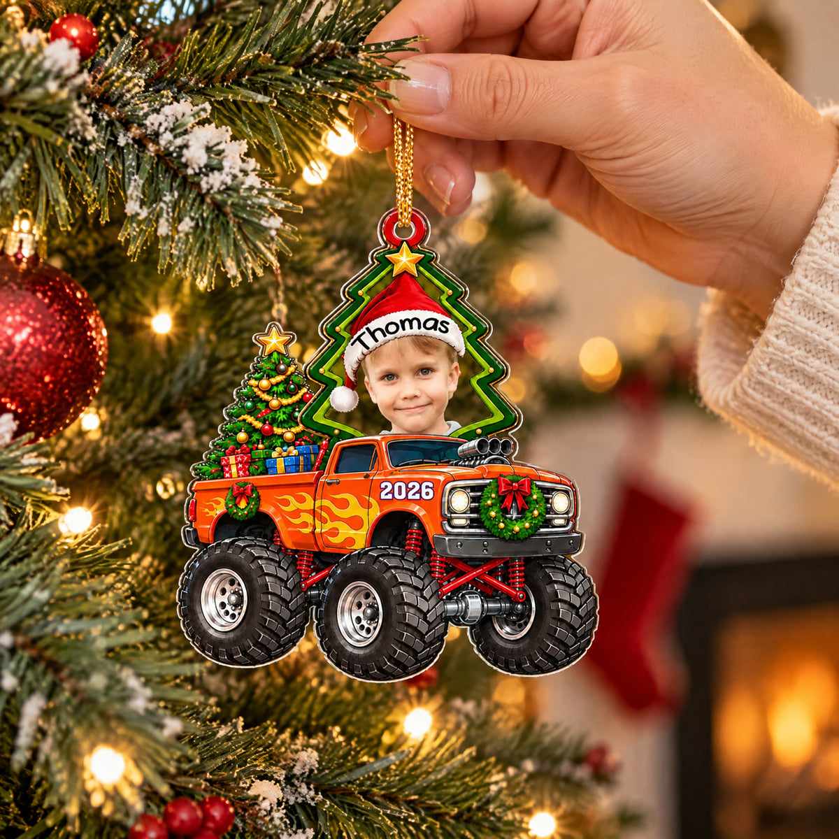 Monster Truck Personalized Acrylic Ornament held up near tree branches with a fireplace and stocking behind