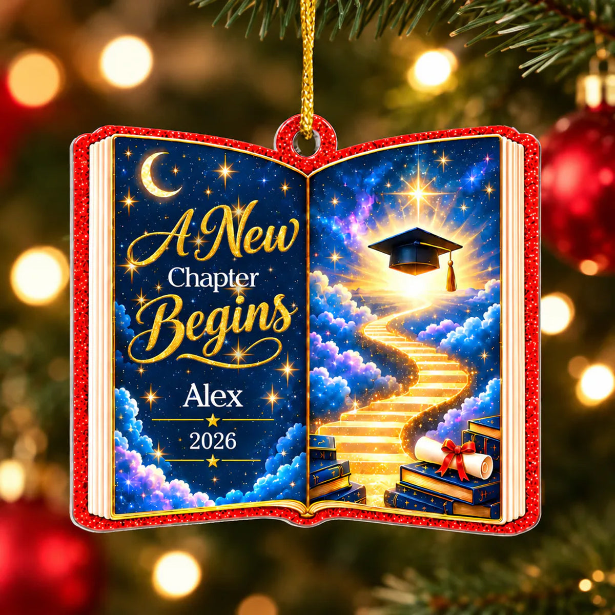 Personalized acrylic celestial graduation ornament hanging on a decorated Christmas tree with warm lights