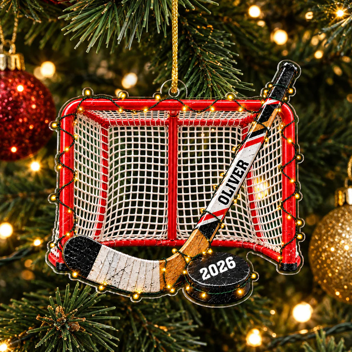 Personalized Acrylic Hockey Ornament hanging on a pine tree with string lights and a gold bauble nearby
