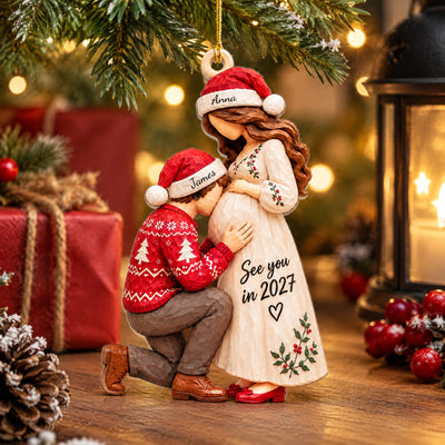 Personalized Acrylic Christmas Ornament standing on a wooden surface near a red gift, pinecone, berries and a lantern