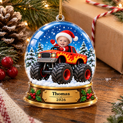 Personalized monster truck snow globe acrylic ornament on a wooden table with pinecone, berries and wrapped gift