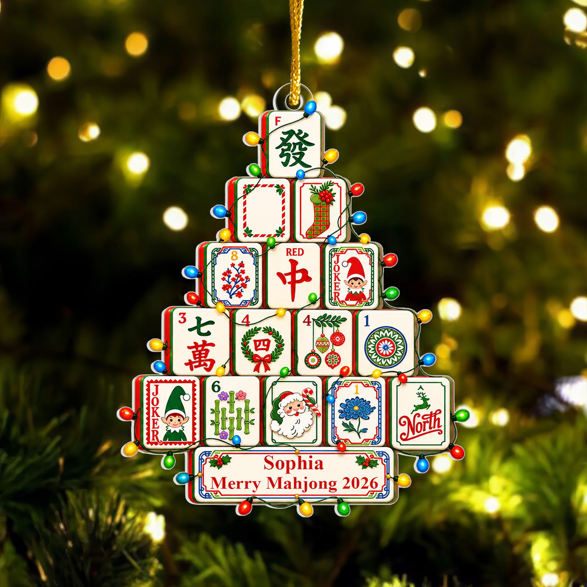 Personalized Mahjong Christmas Tree Acrylic Ornament hanging on a softly lit tree with blurred golden lights