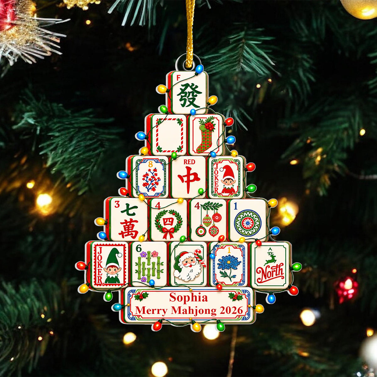 Personalized Mahjong Christmas Tree Acrylic Ornament against dark green pine branches and warm lights