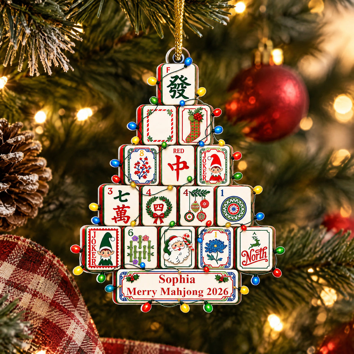 Personalized Mahjong Christmas Tree Acrylic Ornament on a tree beside a pinecone and plaid ribbon