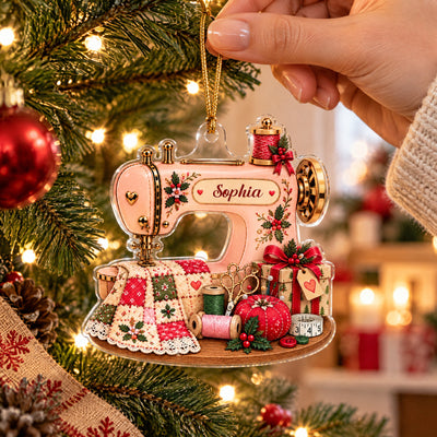 Personalized Sewing Machine Acrylic Ornament held by a hand beside red baubles and a lit Christmas tree