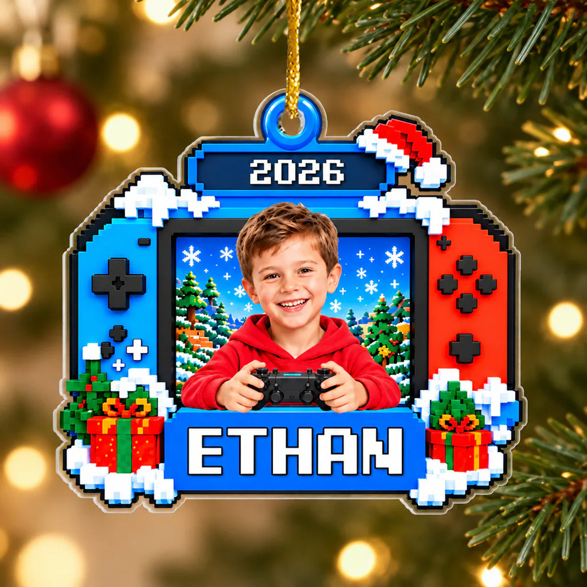 Personalized Pixel Game Console Acrylic Ornament hanging on a tree with a smiling boy, name and year, red bauble behind