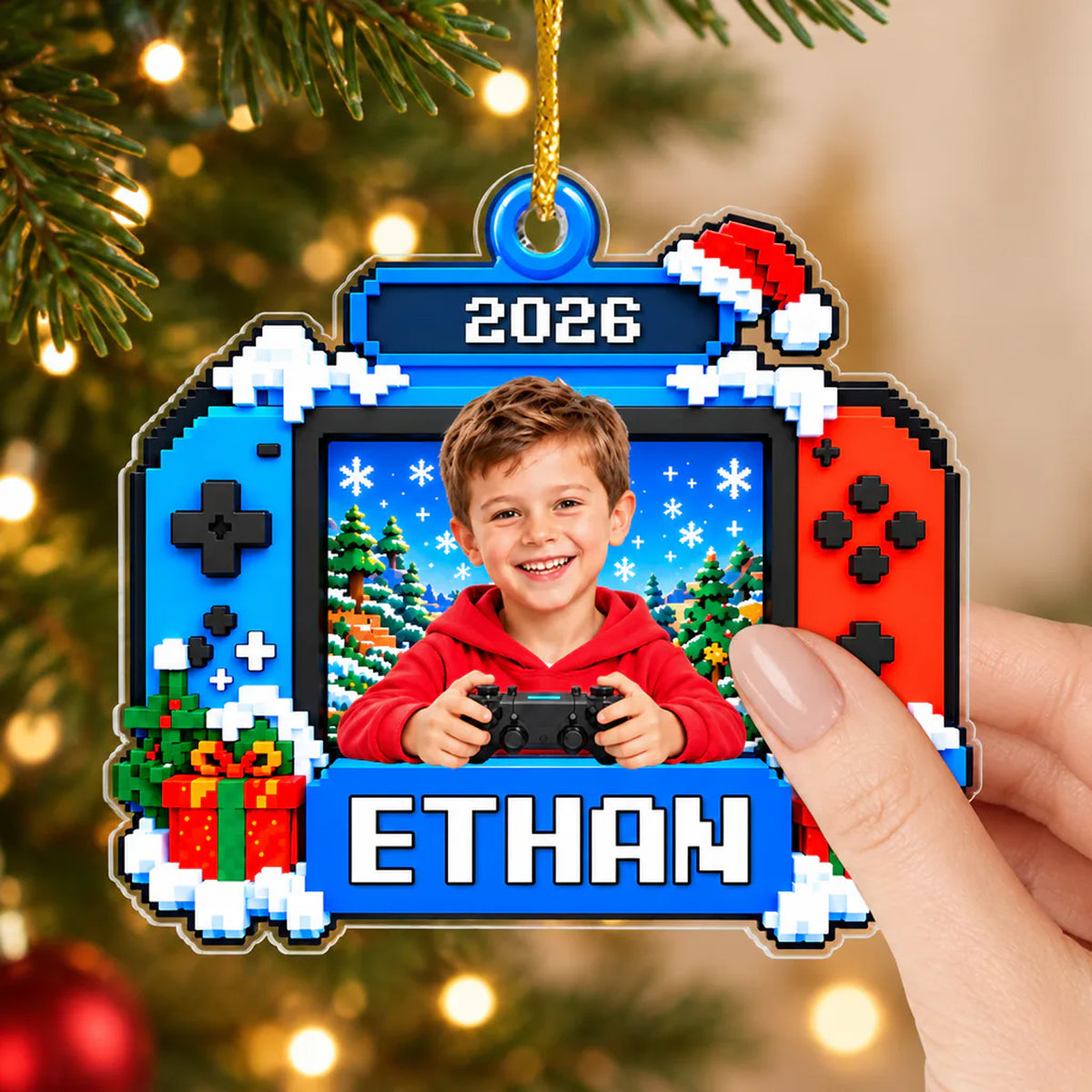 Personalized Pixel Game Console Acrylic Ornament held by a hand against tree lights, showing a boy with a controller