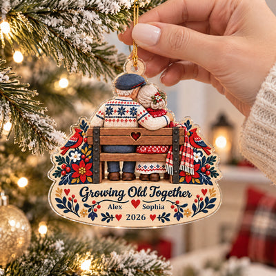 Growing Old Together Personalized Acrylic Ornament held by a hand on a gold cord beside a frosted tree