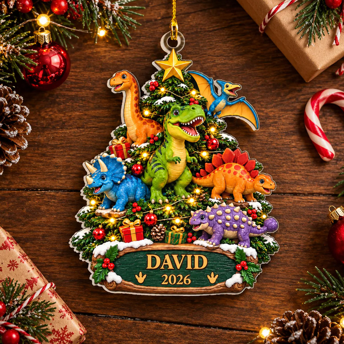 Personalized acrylic dinosaur ornament reading David 2026 on a wooden table with candy canes and gift boxes