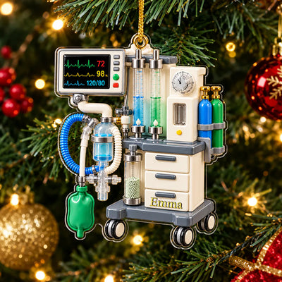 Personalized anesthesia machine acrylic ornament hanging on a lit Christmas tree branch with red and gold baubles