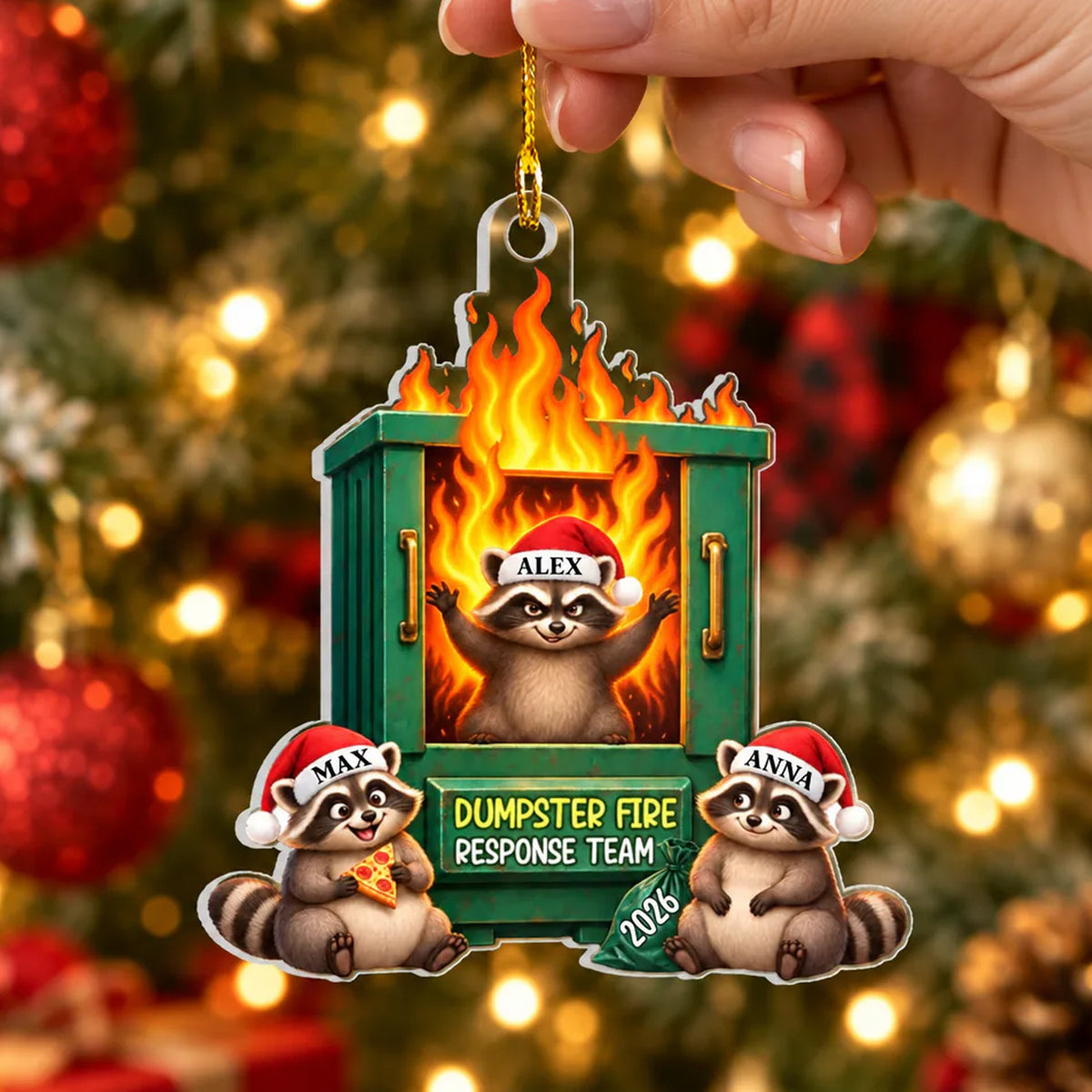 Dumpster Fire Response Team Personalized Acrylic Ornament held by a hand, three raccoons in Santa hats, tree lights behind