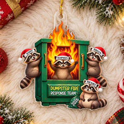 Dumpster Fire Response Team Personalized Acrylic Ornament lying on white fur with four raccoons, red baubles and pine around