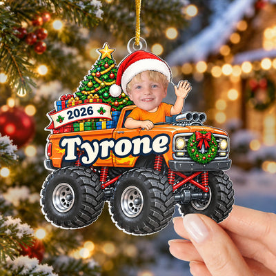 Personalized monster truck acrylic ornament, orange truck held in a hand near a decorated tree with lights