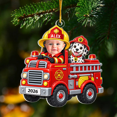 Personalized acrylic ornament baby fire engine hanging from a pine branch, name ALEX on the helmet and 2026 on the plate